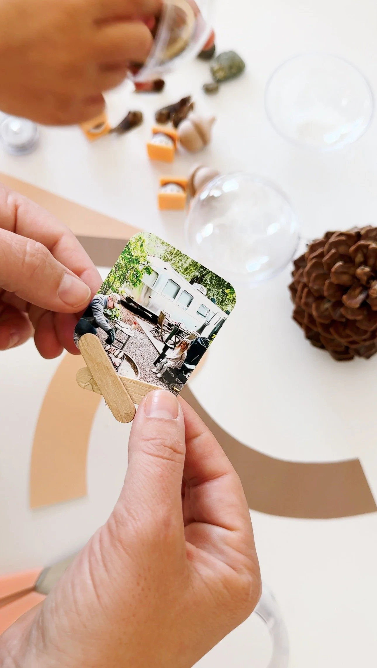 Trimming a small family camping photograph to fit inside a clear keepsake globe.