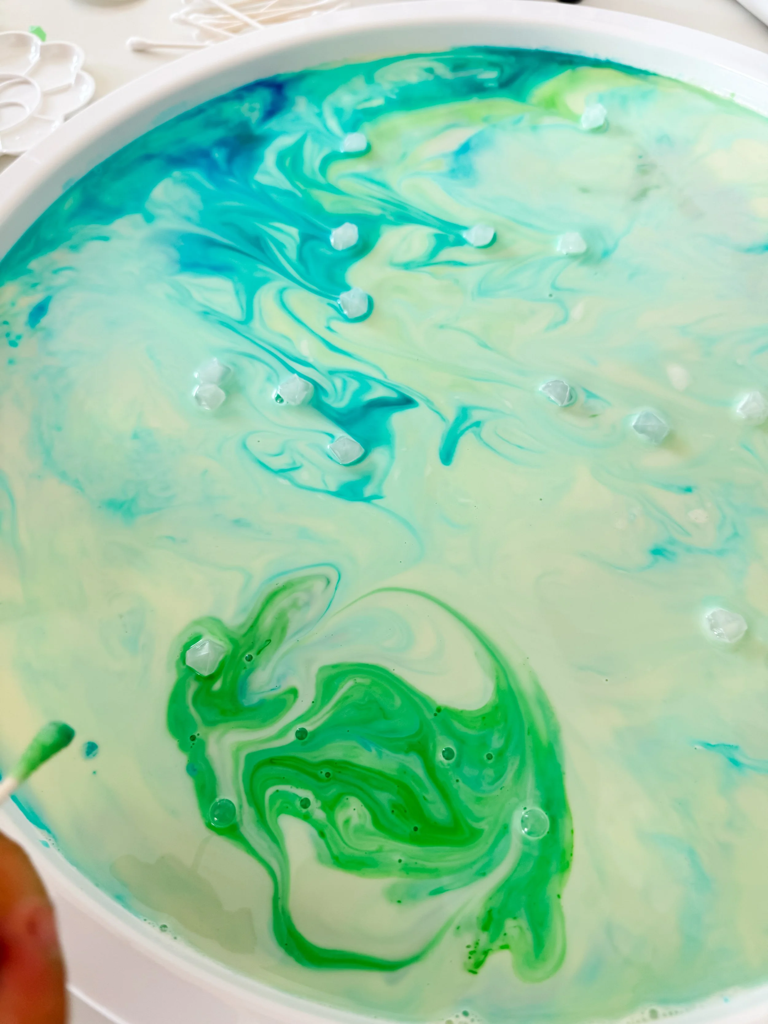 Green and blue Magic Milk patterns resembling separate regions of the northern lights.