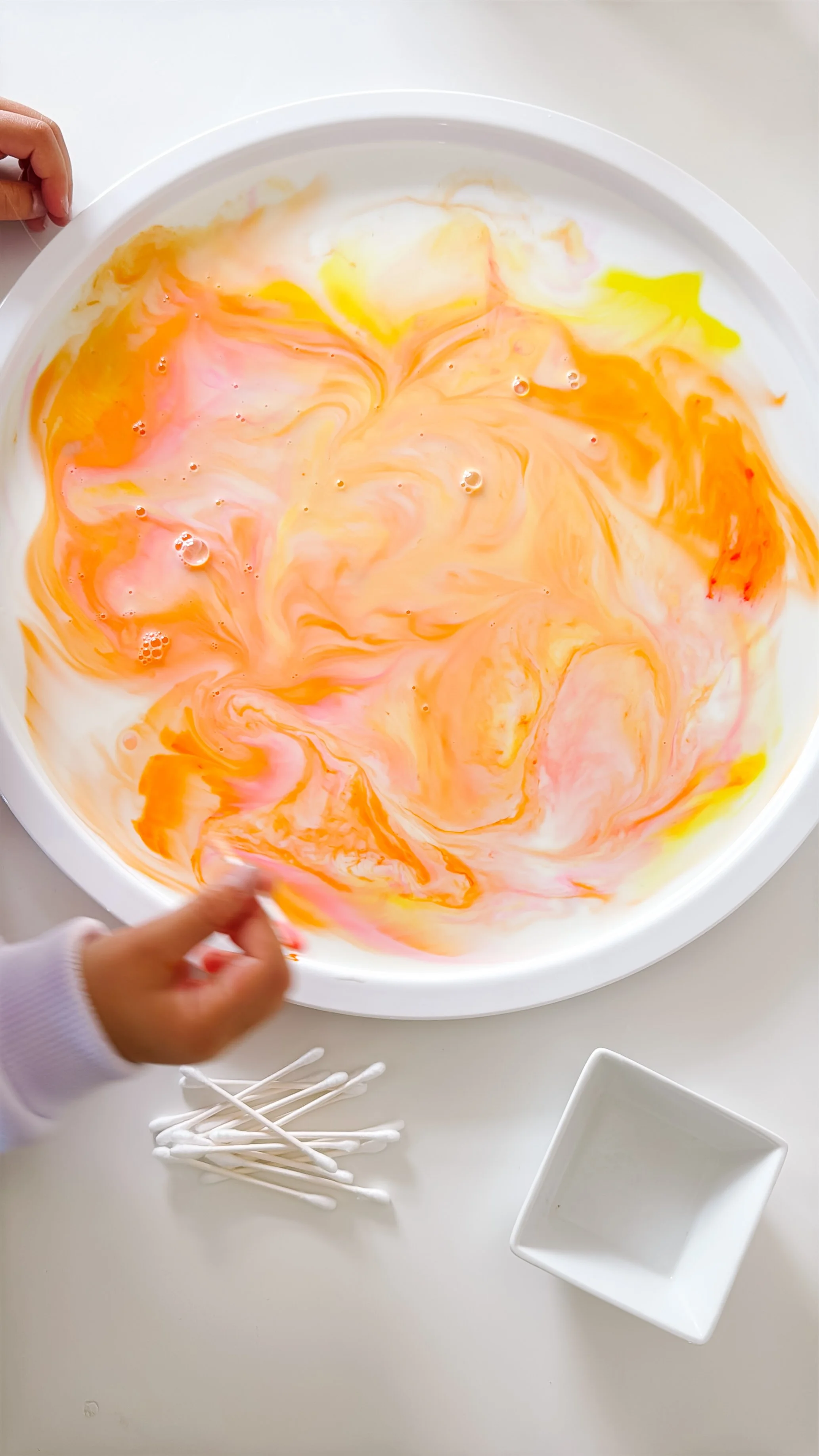 Warm food coloring drops in milk for a sunset milk science experiment.