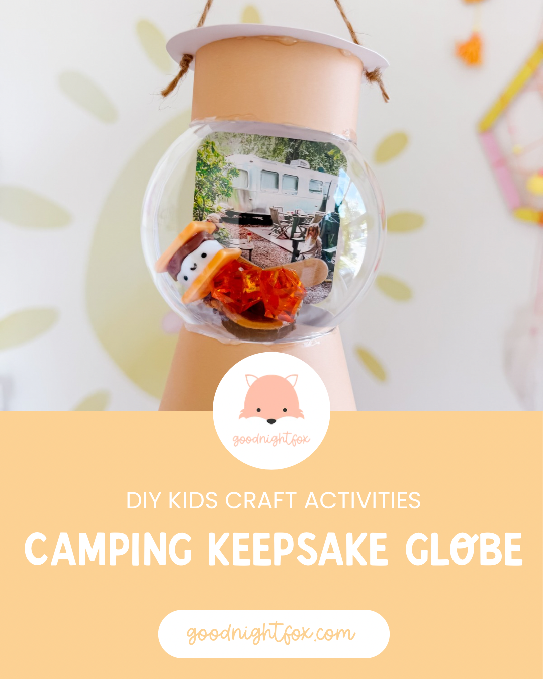 Finished camping keepsake globe shaped like a lantern with a family camping photo, miniature s'more, orange gems, and glowing tea light.