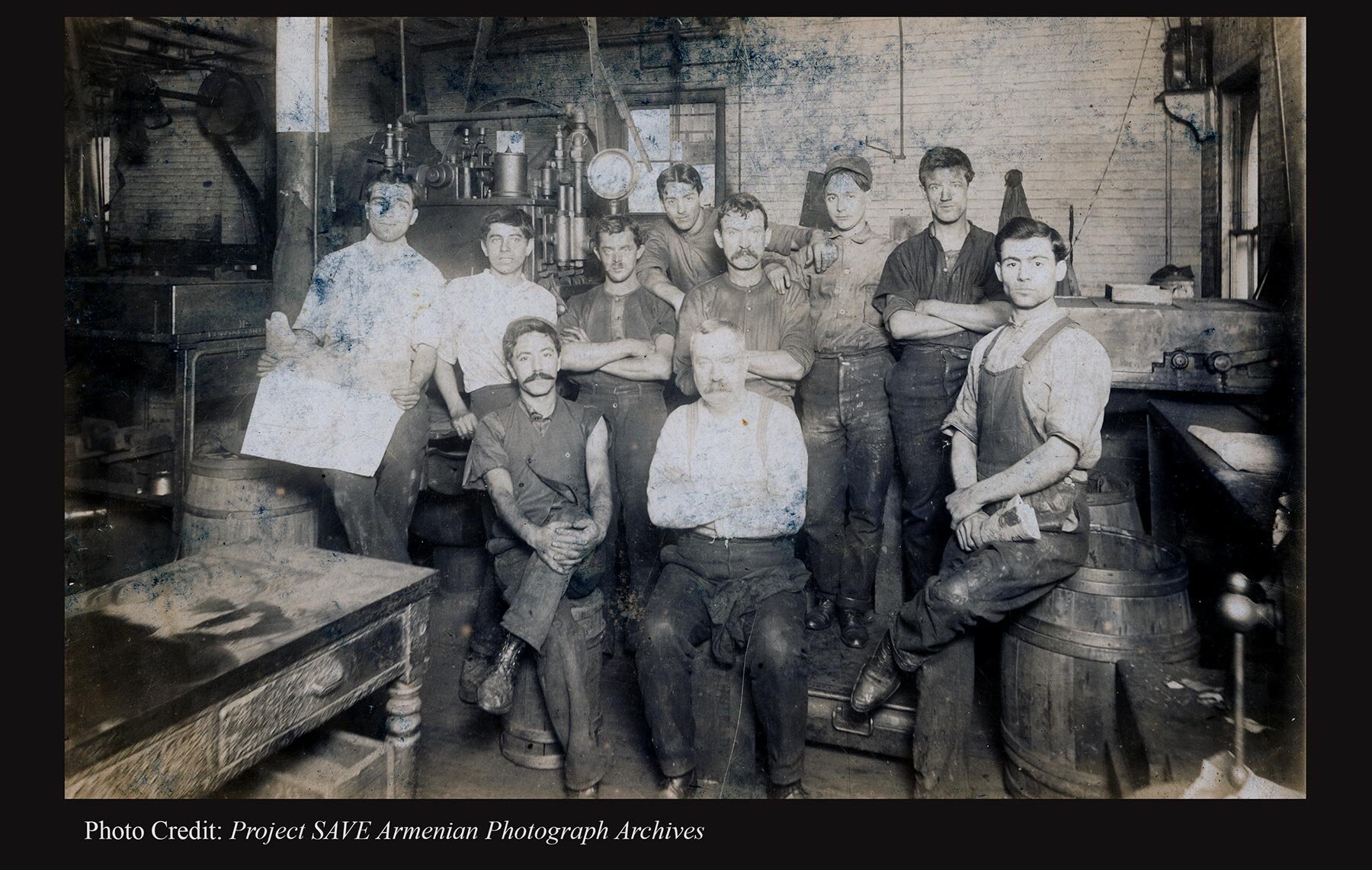  Empire City factory floor with Mardiros Der Sarkis Tashjian (seated left) and John Garabed Hurmuze (seated right). (Photo Credit: Project SAVE Armenian Photograph Archives) 