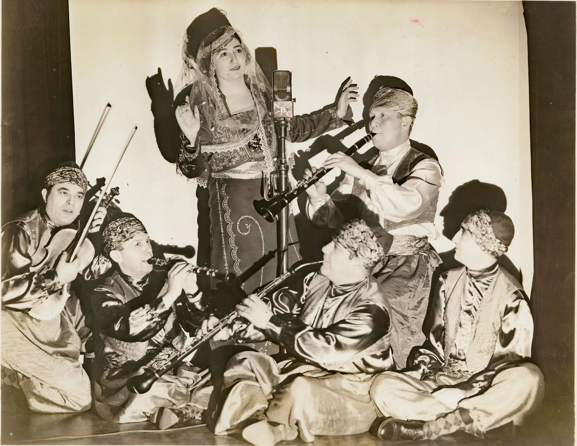Marie Arakian and orchestra in orientalist costumes, circa 1938-1960. Photo by Ray Lee Jackson, NBC studio, New York, New York. (Image: Project SAVE Armenian Photograph Archives, Courtesy od Danielle Hatchadoorian Rydber)