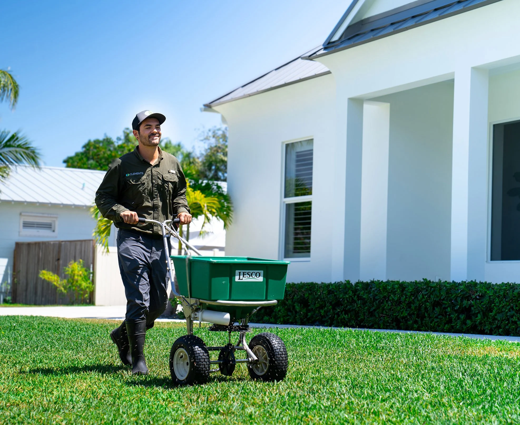 Clements Pest Control technician applying fertilizer to a residential lawn in Vero Beach, FL