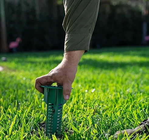 Technician installing a termite bait station in Sebastian