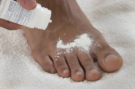 34447879_S_african_american_foot_odor_powder_toes_hand.jpg