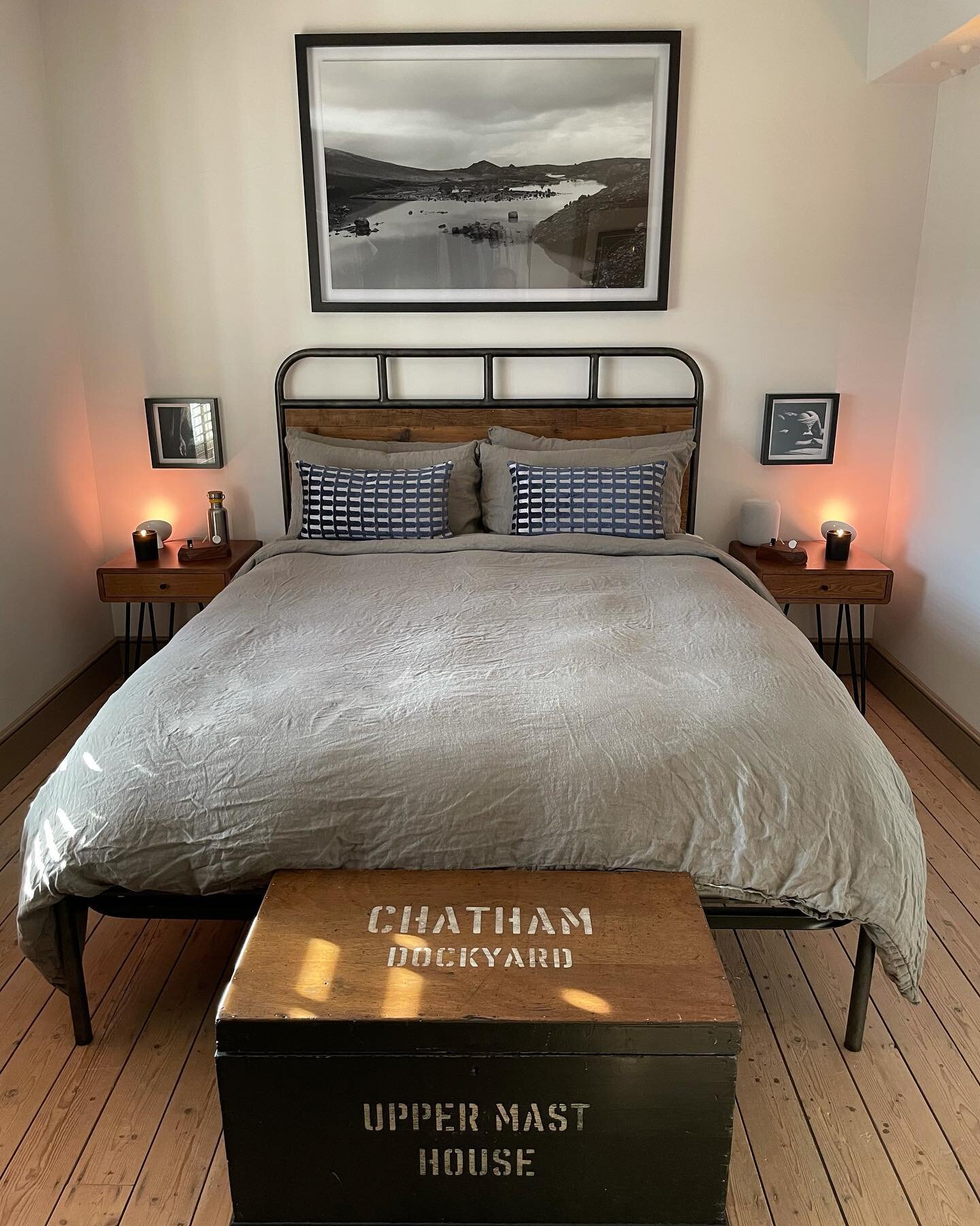 Simple earth tones adorn our master bedroom: warm wood, moss linen duvet from @bedfolkhq, midnight blue throw pillows from @westelmuk, black and white photography, and the soft orange glow of non-invasive lighting. We regularly rotate a few shades of