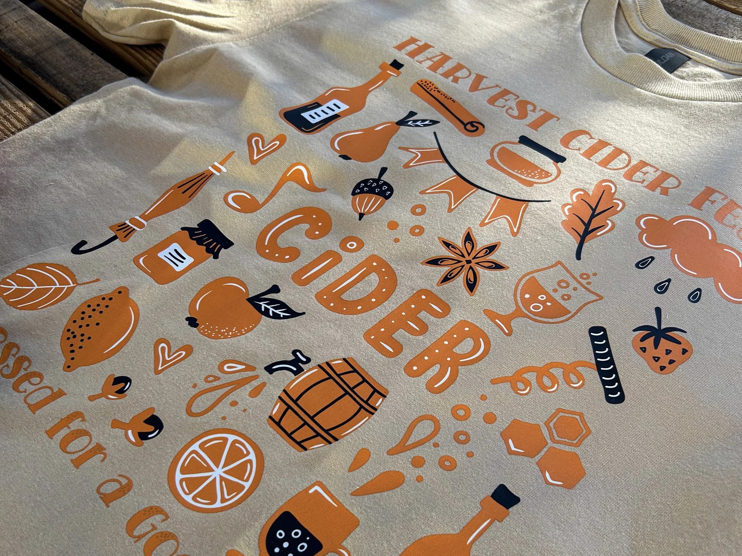 Close-up of a Harvest Cider Fest full-color colorVIBE DTF design printed on a tan Gildan T-shirt.