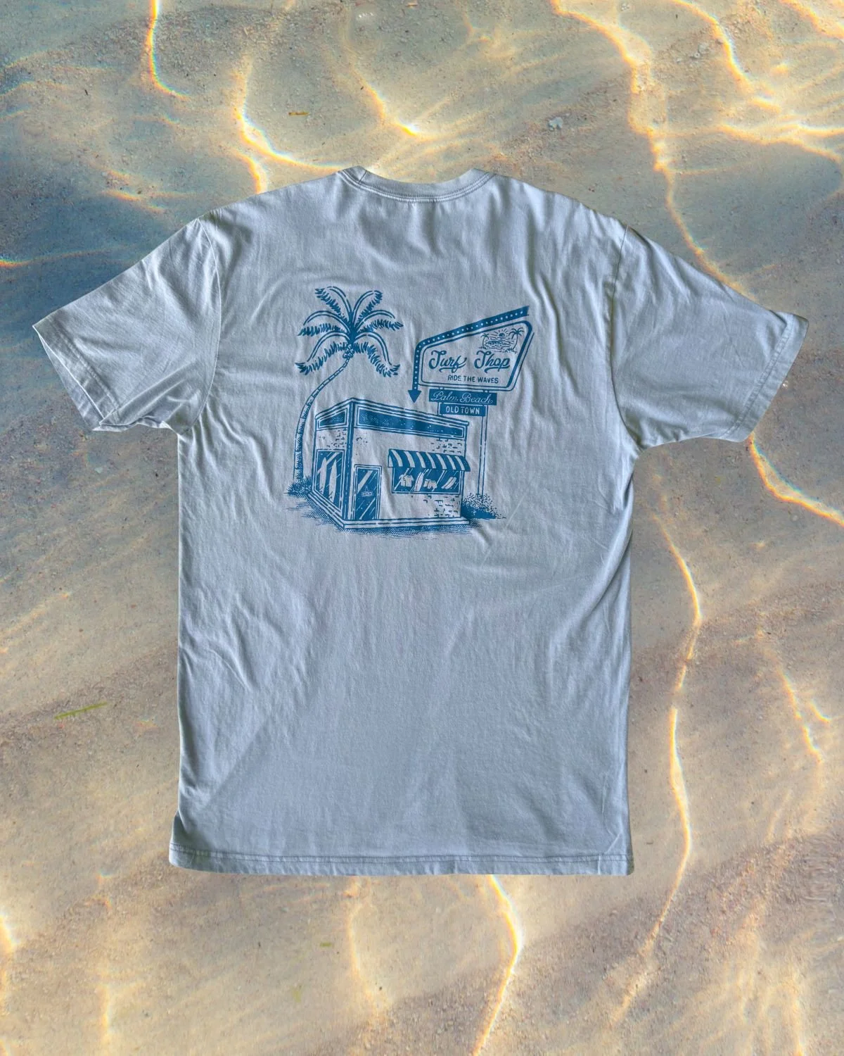 Vintage wash surf shop t-shirt displayed as part of a summer scene