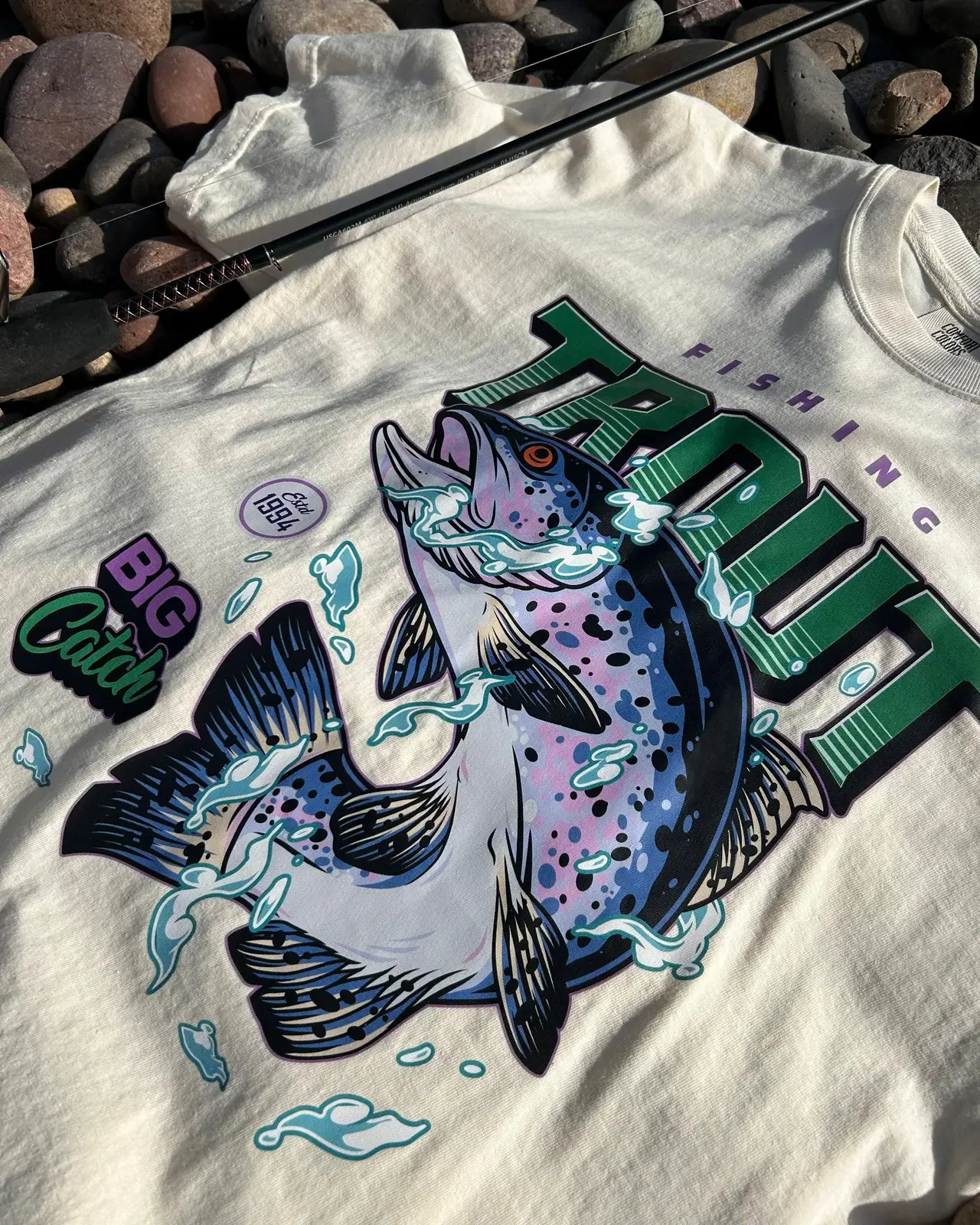 Detailed full-color trout graphic on a cream shirt
