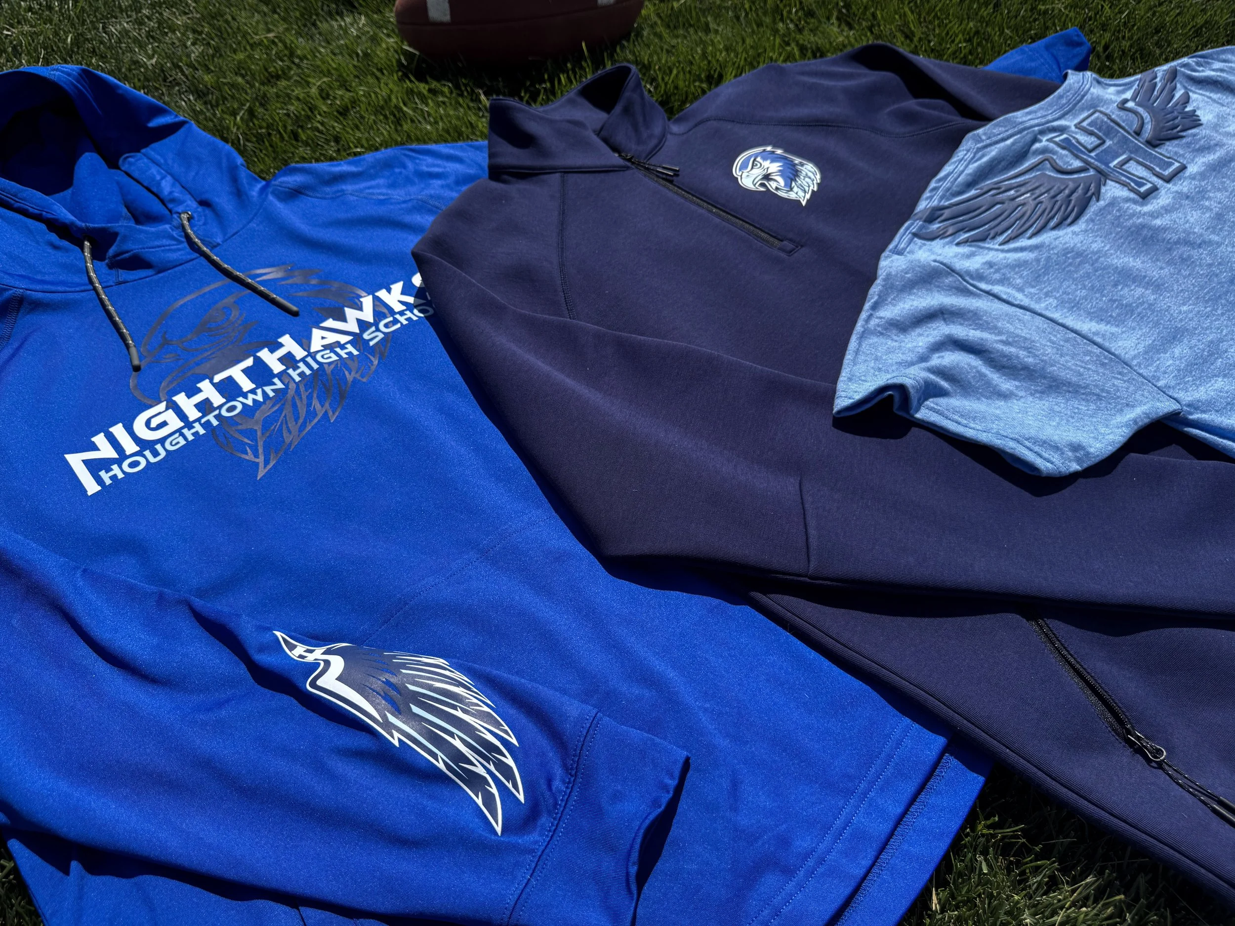 Three coordinated spirit wear and team wear pieces decorated with heat transfers across distinct garment styles