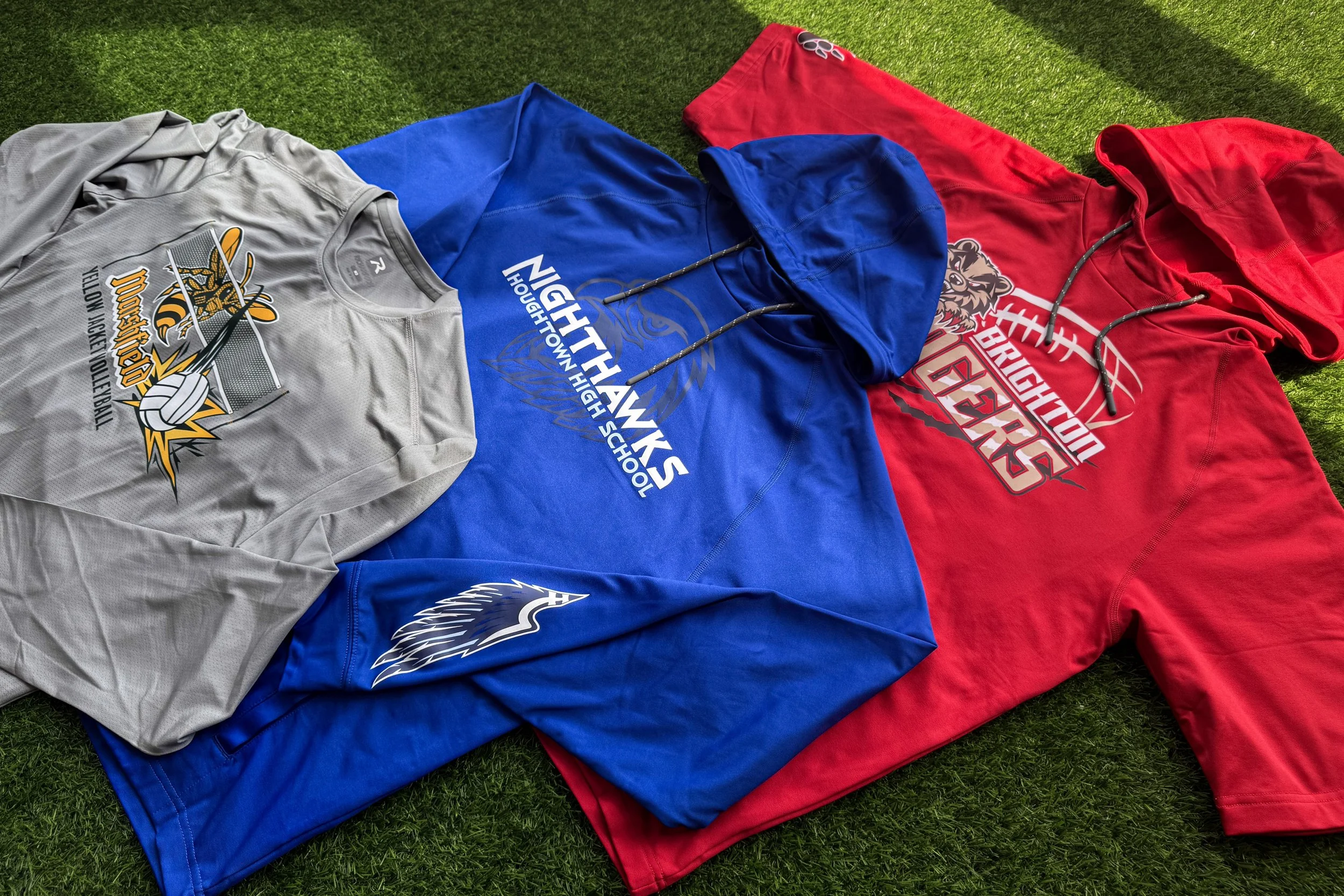 Three-piece Modern Performance athletic collection featuring a football hoodie, volleyball long sleeve, and training hoodie decorated with colorVIBE DTF and Howard Multi-Purpose transfers on poly-spandex performance fabric