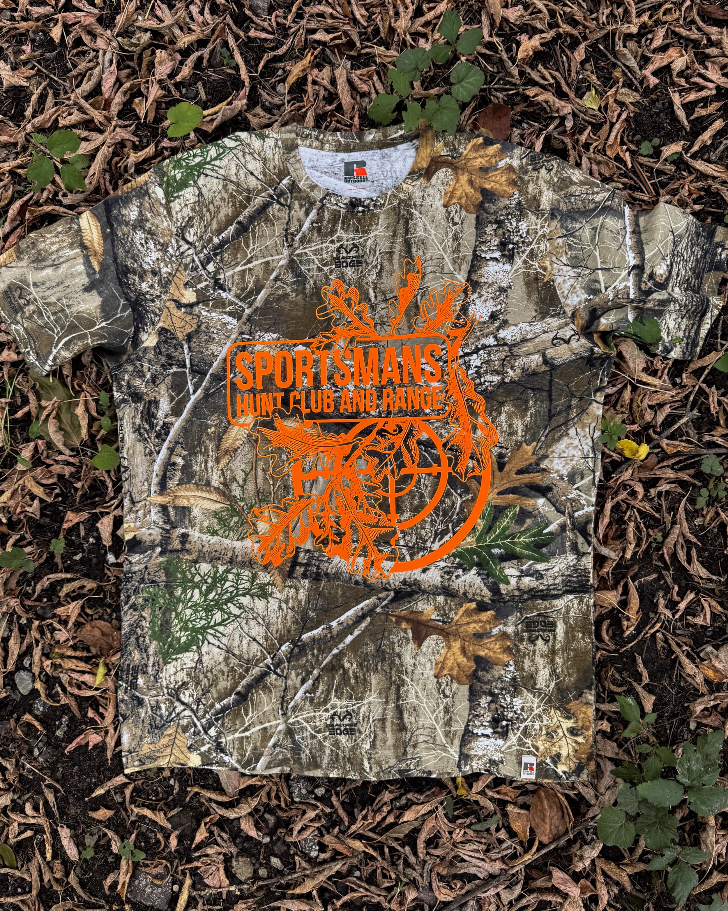 Sportsmans Hunt Club and Range Realtree camo tee with a Neon Orange Howard Multi-Purpose graphic.