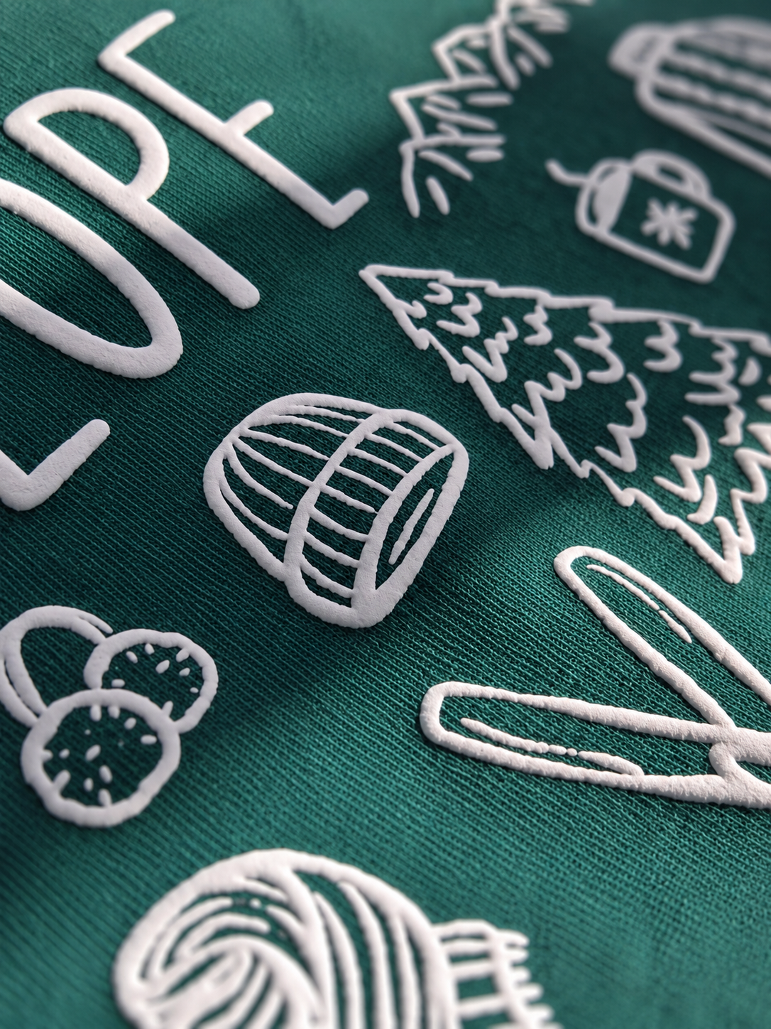 Close-up of raised white Puff transfer on teal fleece