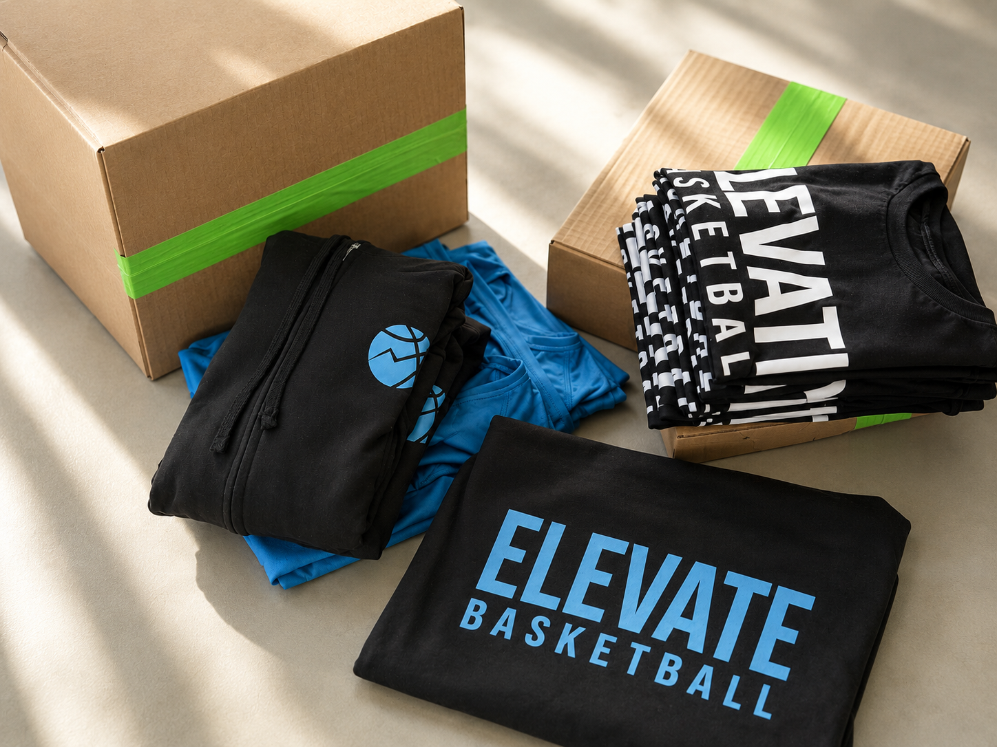 Organized printed garments near shipping boxes for apparel finishing and fulfillment.