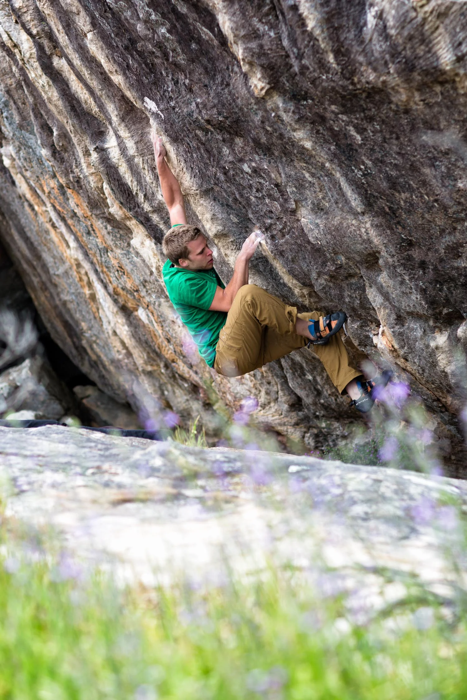 Spring flowers in the foreground, busting climber on Bitch Slap (V7) in the background. Kamil Sustiak