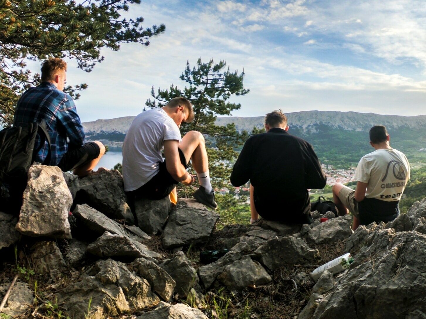 four-men-seated-on-rocks-facing-mountain-1070492.jpg