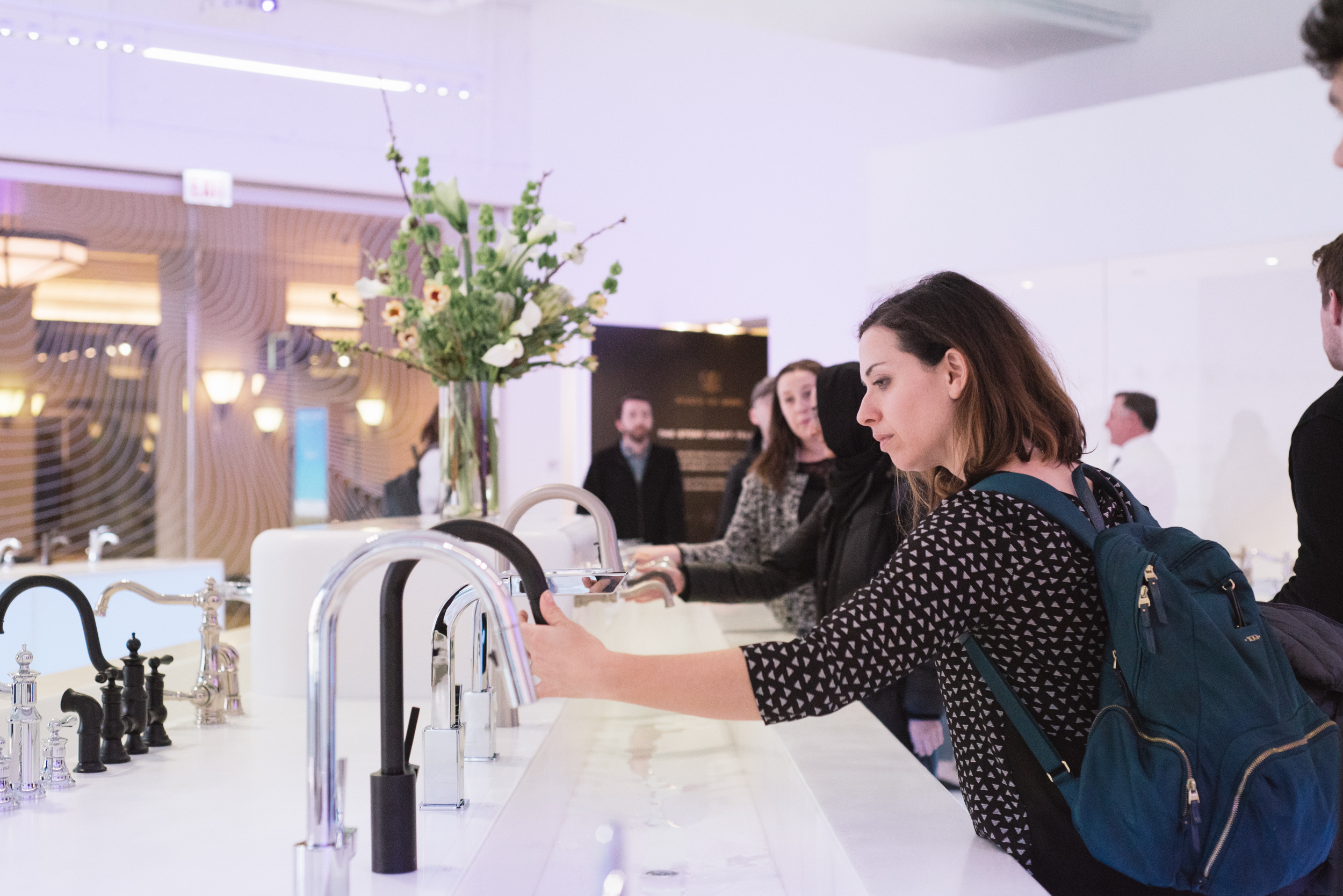 Romina tests an Align Matte Black Kitchen Faucet at the Moen showroom