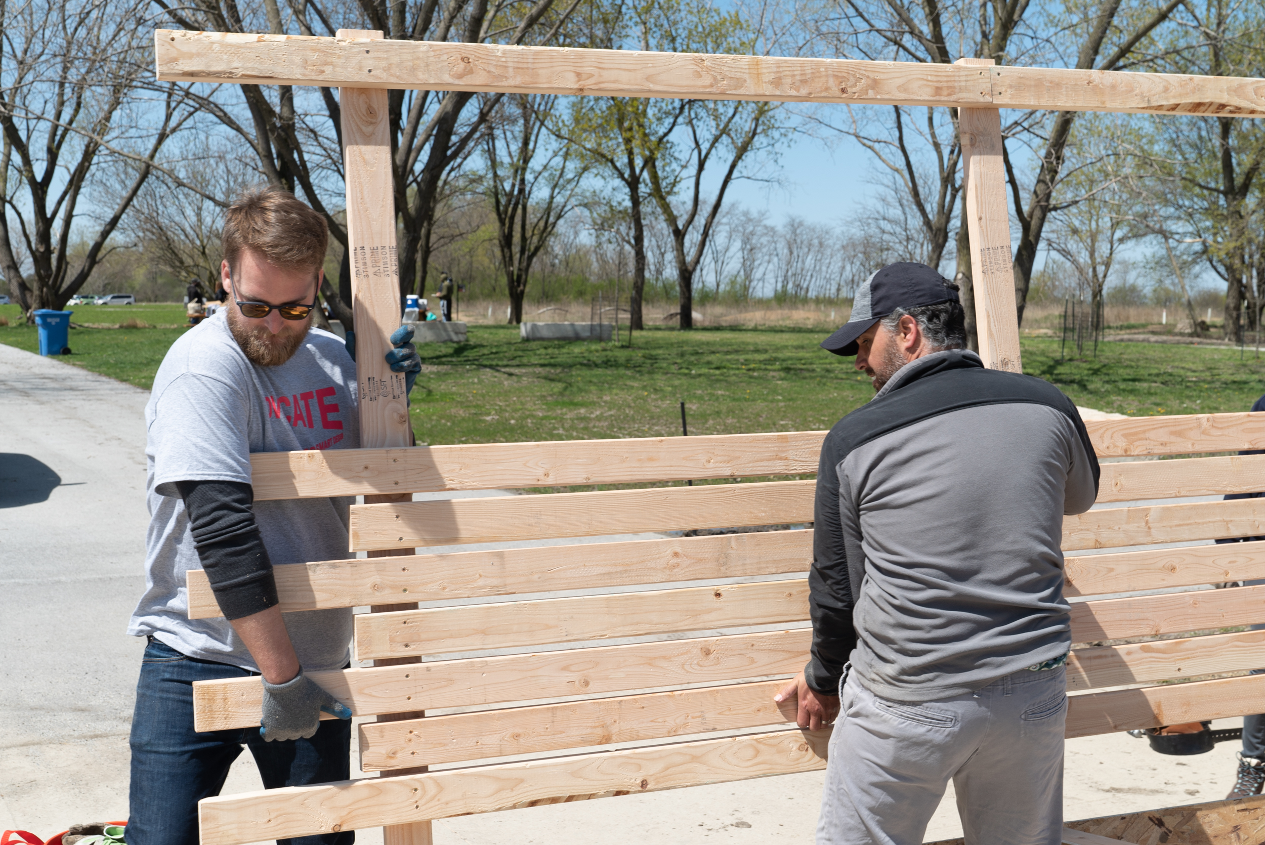 Alex helps carry a newly-built wall.