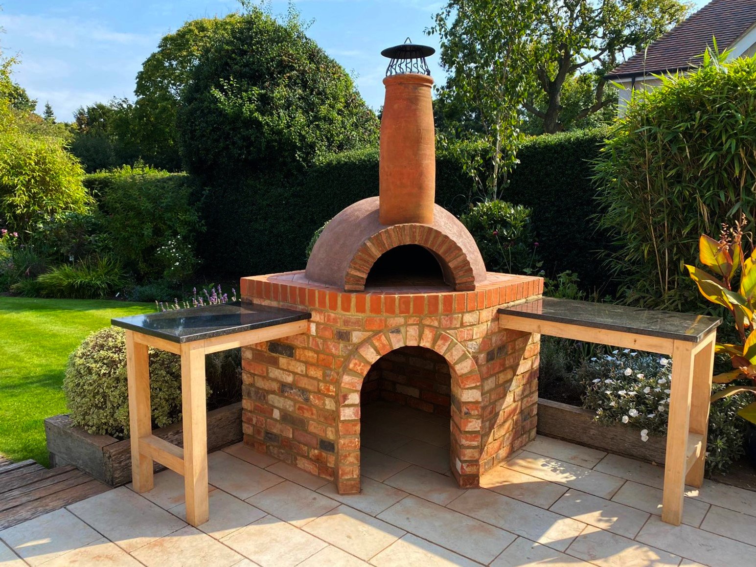Standard wood fire pizza oven on a reclaimed corner brick plinth