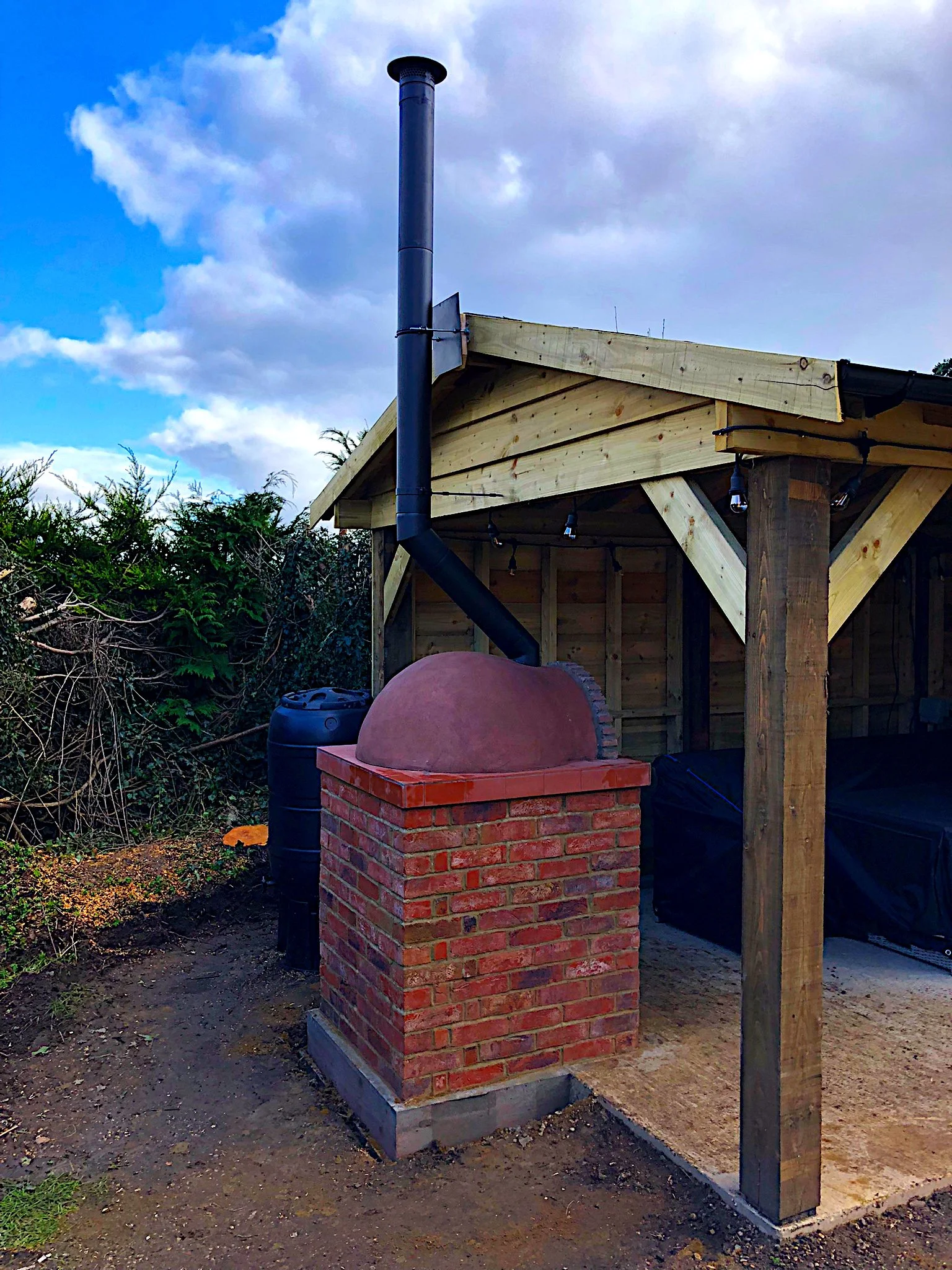 Mini Oven half under a gazebo, show the flue install