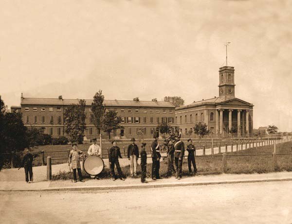 A band poses in front of Naval Terrace and the Dockyard Church