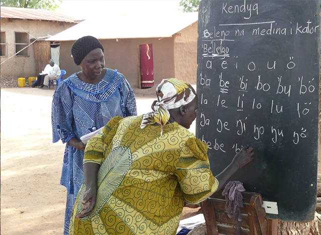 Women learn to read and write in their native languages as the first step in business development.