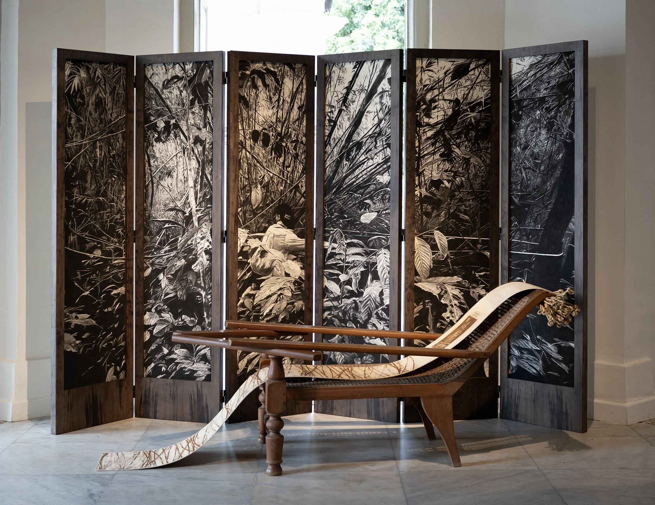 Rotan Rattan: Notions of Labour — Kapuas Hulu     2025  Charcoal on paper set in wood and rattan screen 184 x 246 x 4cm    Rotan Rattan: Notions of Labour — Uttar Pradesh   2025  Wood, Plantation Chair, Rattan Canes 76 x 190 x 79 cm