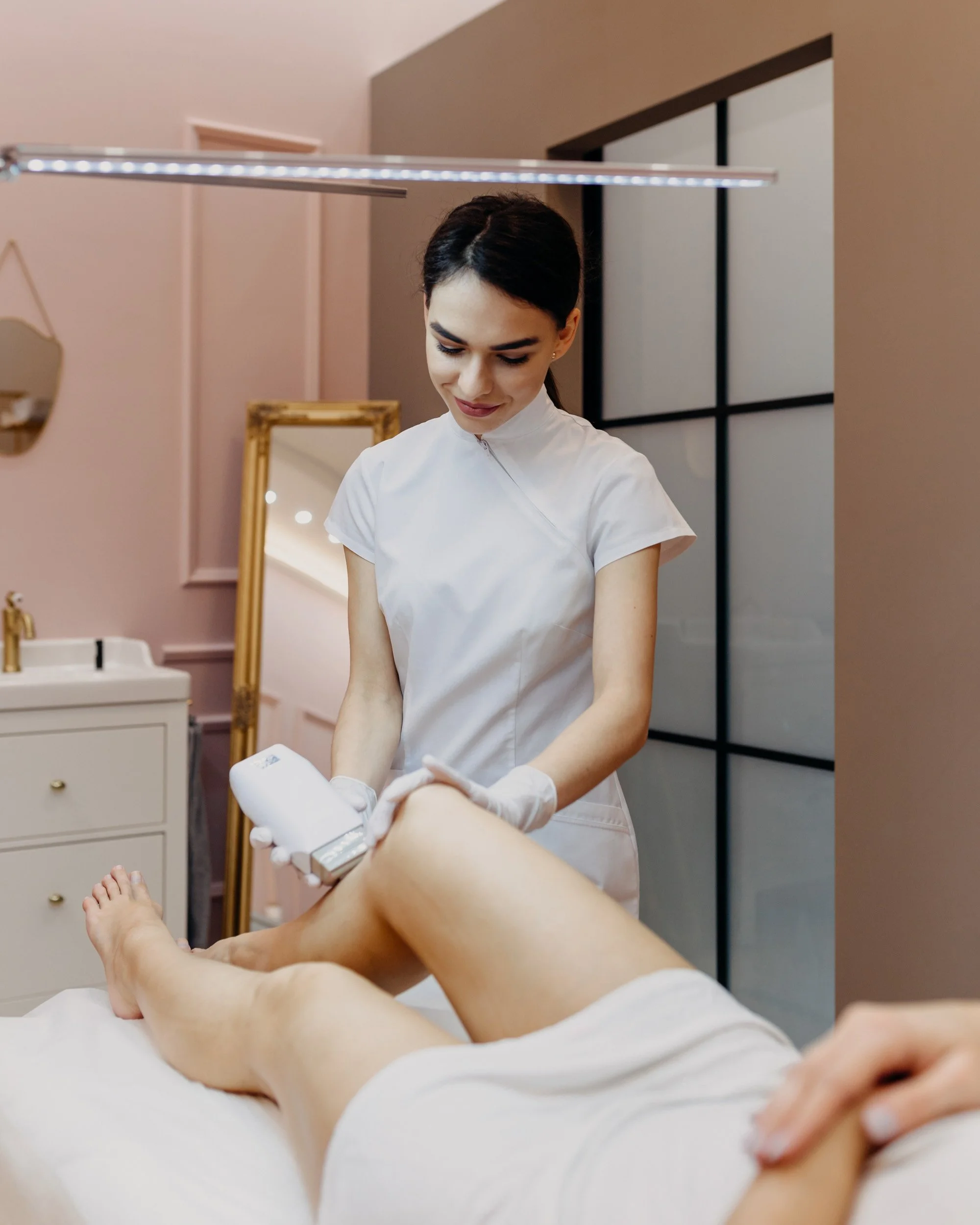 A healthcare professional performing a pedicure on a patient's foot in a spa or clinic setting.