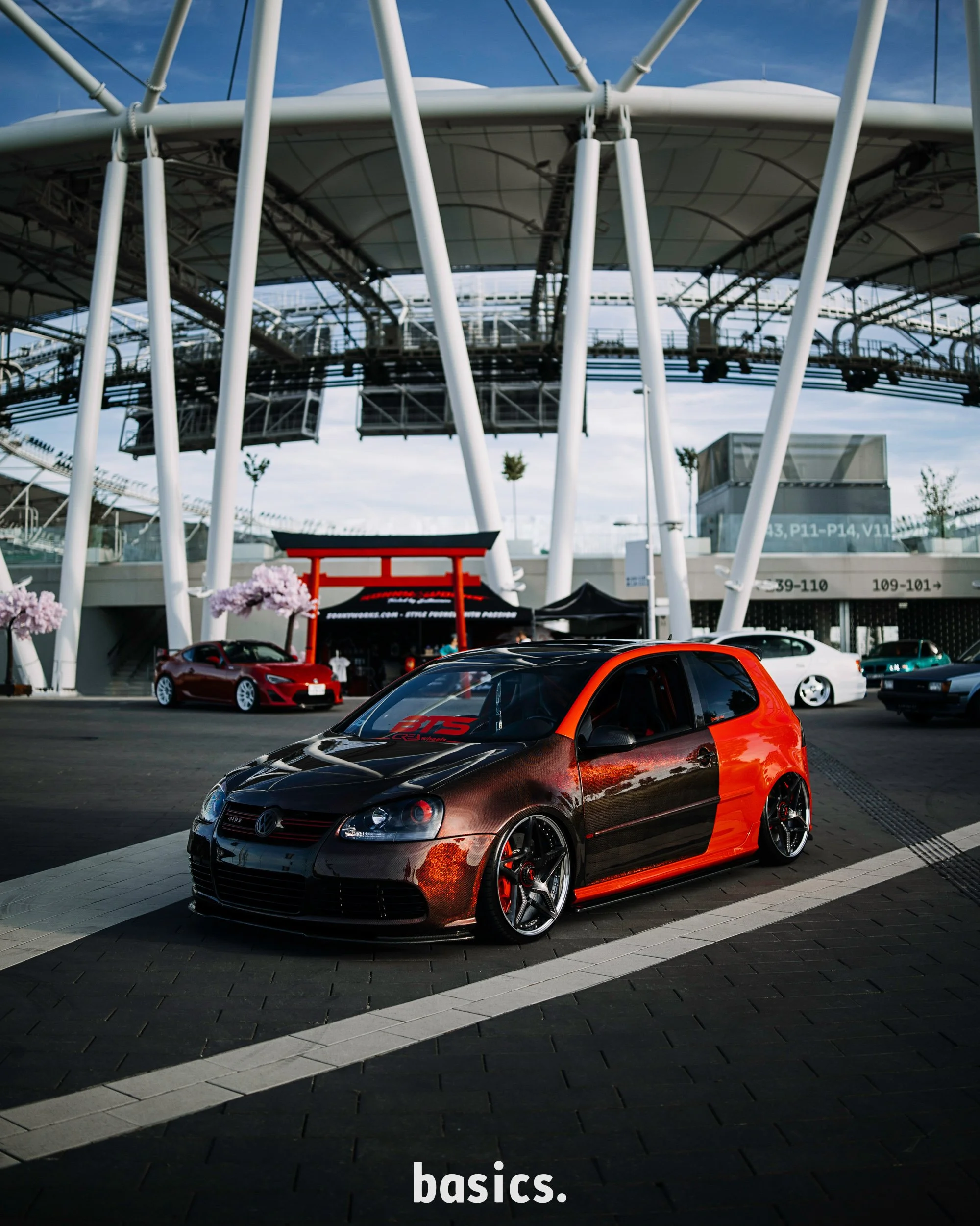 Épített piros volkswagen golf gti mk5 a nemzeti atlétikai központ stadionnál fotózva a Basics 2026 rendezvényen