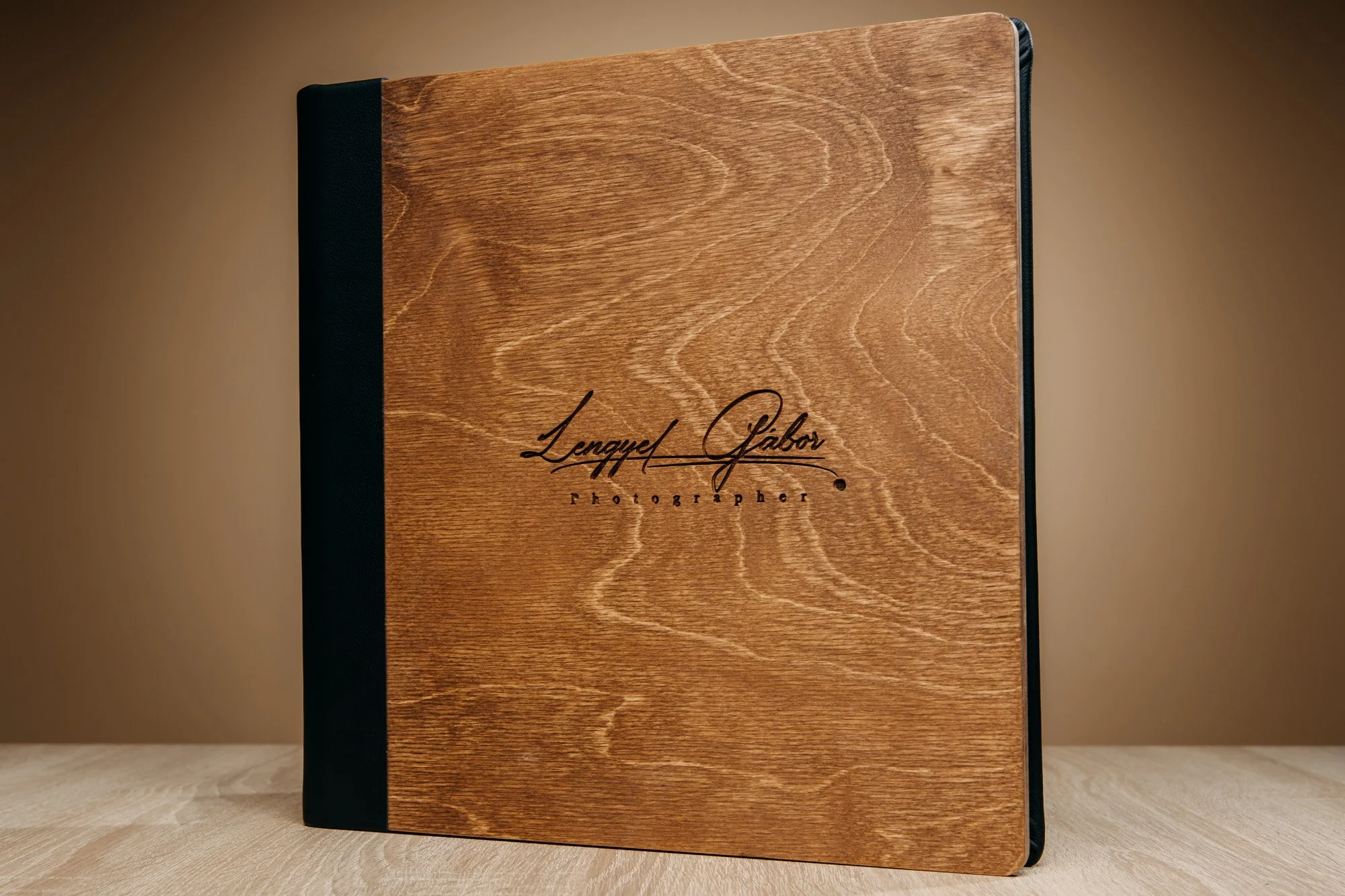 Wooden photo album with black cover edges, exhibiting the signature of Lanyel Gabor and the word 'photographer' on the front.