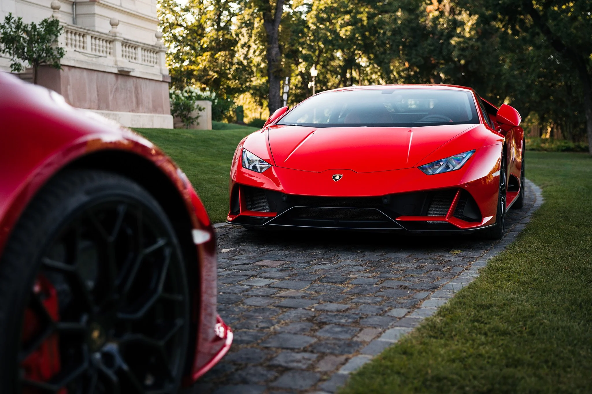 Két piros Lamborghini Huracan fotózása a Botaniq kastélykertben, Turán.