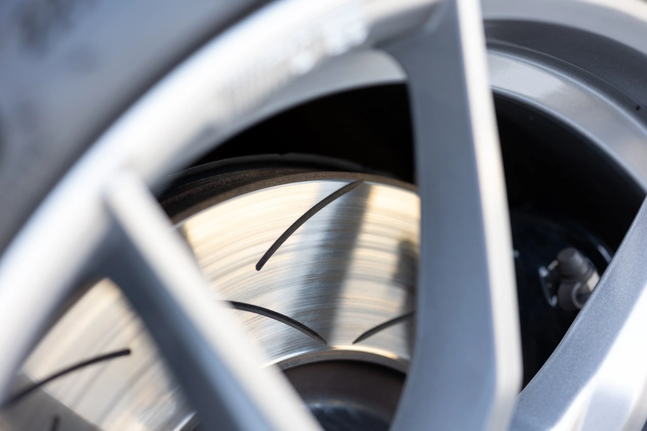 Close-up view of a metallic turbocharger turbine wheel inside the turbo housing.