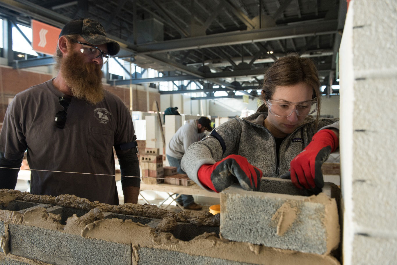 Kelsey Holmes (right) and Jason Bock of BAC Local 1 NB (left) in a hands-on block instruction