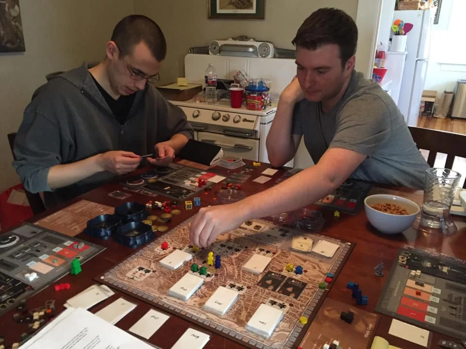 John Brieger (right), at the retreat place working hard placing workers on a worker placement game