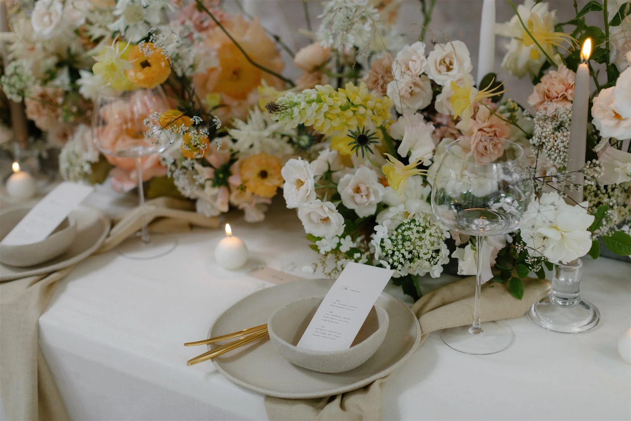 Contemporary wedding dinner table with ceramics and golden cutlery