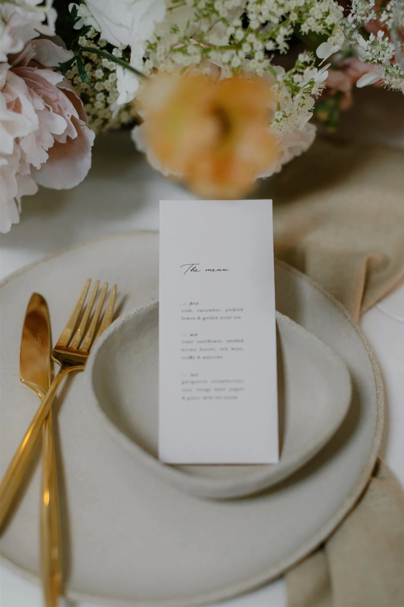 Contemporary wedding dinner table with ceramics and golden cutlery