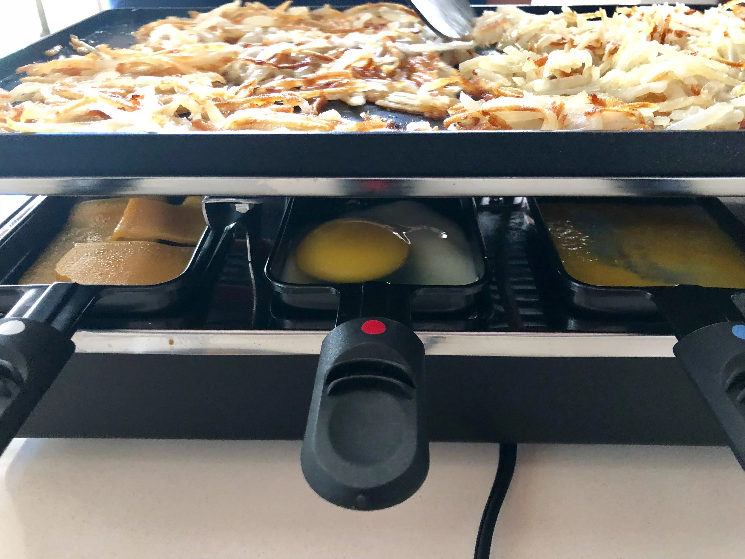 For breakfast, we cooked ham, bacon, and veggies on the griddle top, removed them, then cooked shredded potatoes in the grease. Below, we cooked eggs and melted cheese. We made the BEST hash browns. Waffle House ain't got nothing on our Scattered, Smothered, Covered, Chunked, Topped and Diced Hash Browns!!