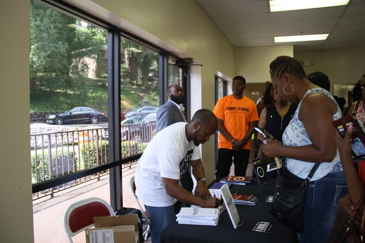 Anthony holding a book signing after speaking at NRS Church