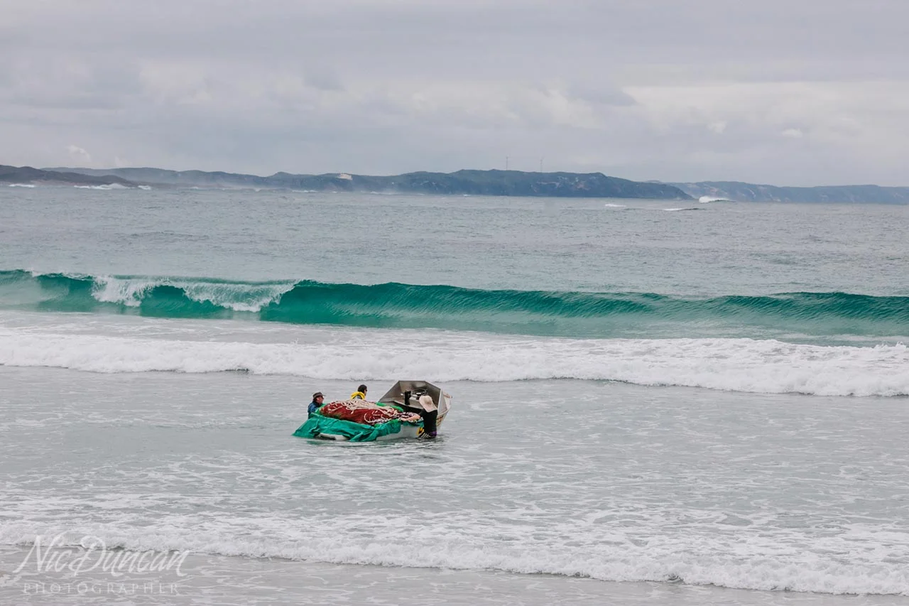 Commercial salmon fishermen, launching their boat with the fishing nets