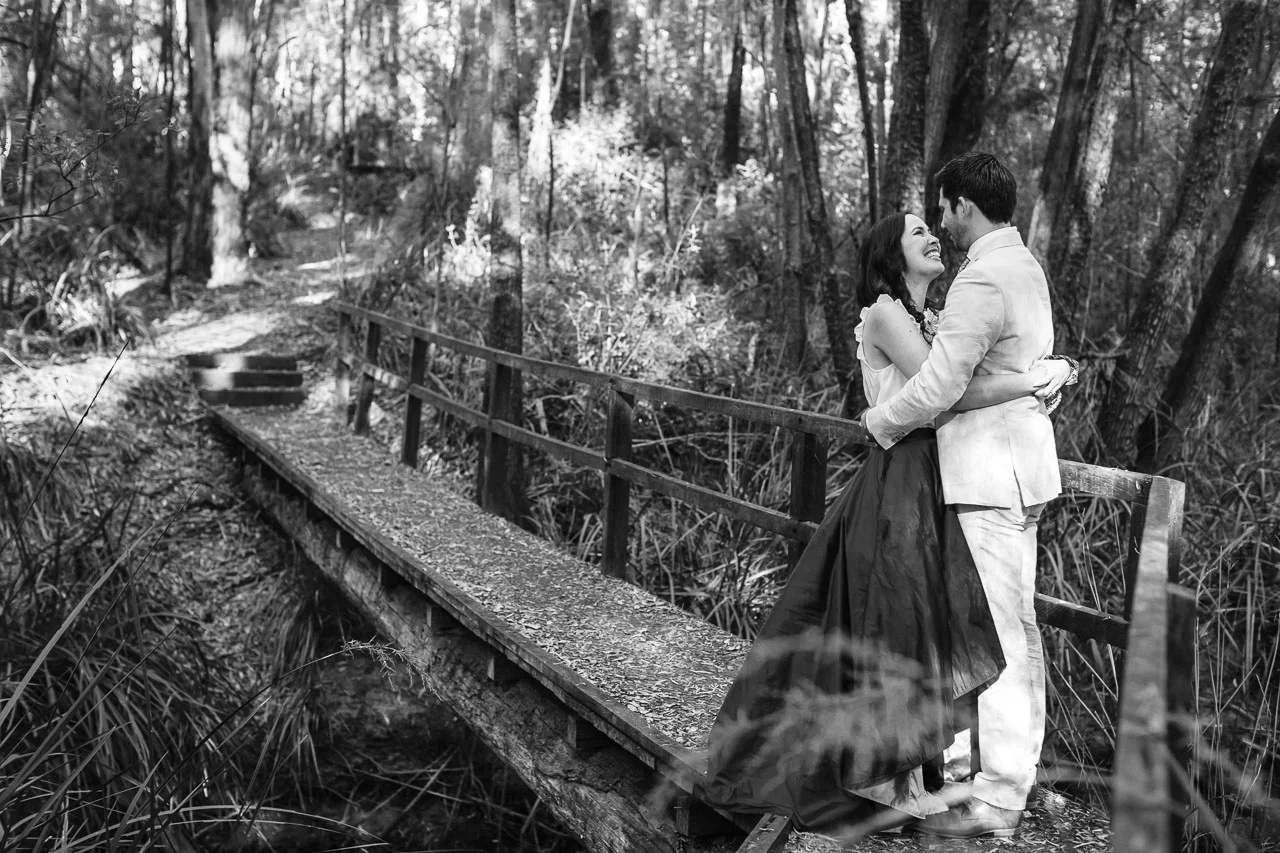 Nic Duncan portrait and wedding photographer, bride & groom on a bridge in the forest