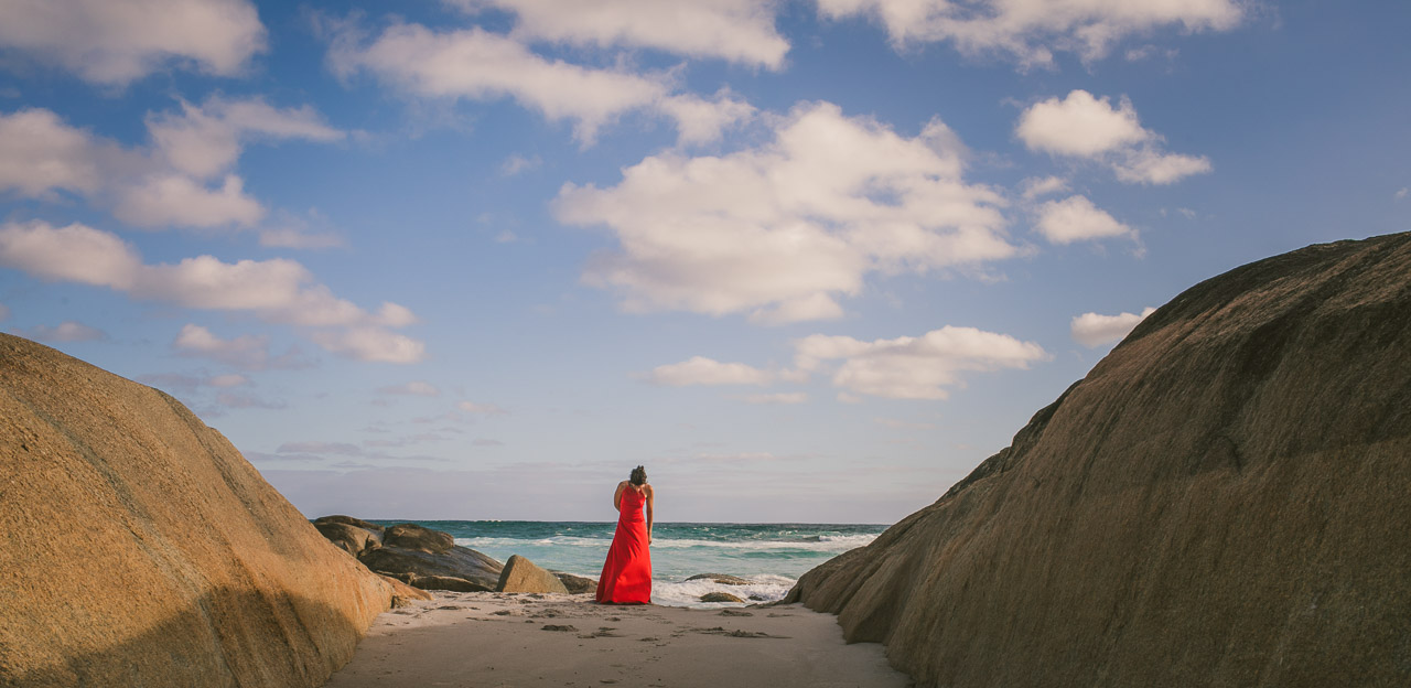Portrait of a woman in a red dress, on the beach
