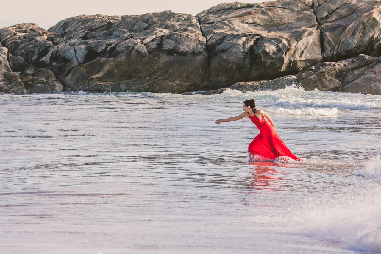 Portrait of a lady in red dress in the ocean,