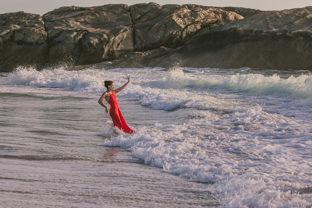 Fire and water, portrait of a lady wearing a red dress in the ocean