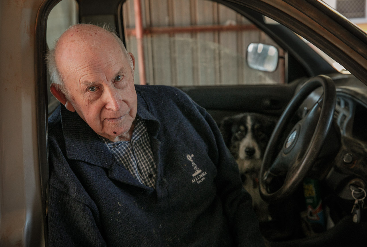 Elderly farmer in his ute with his sheepdog