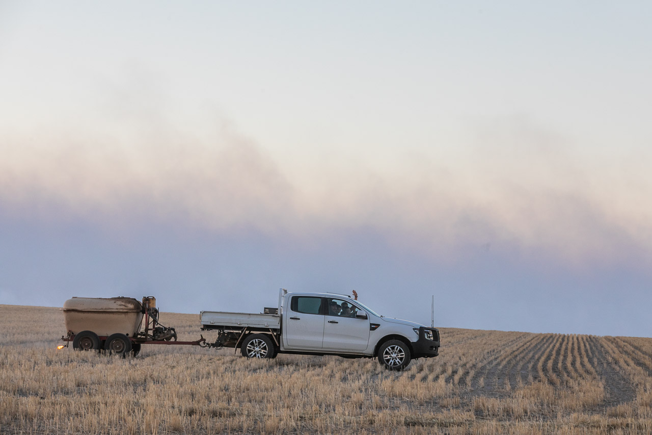 The farmer in his ute setting fires for windrow burning in the wheatbelt