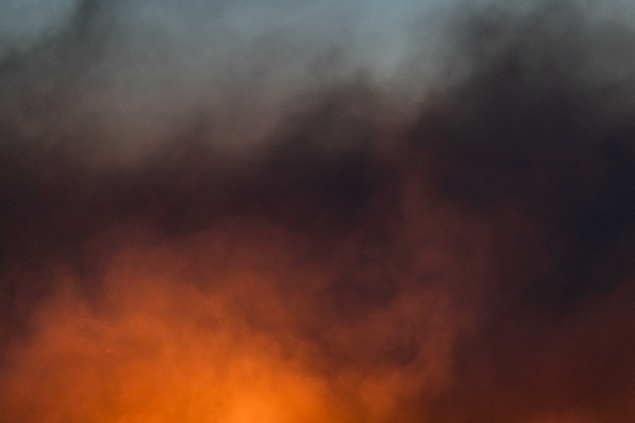 The glowing fire and smoke during windrow burning