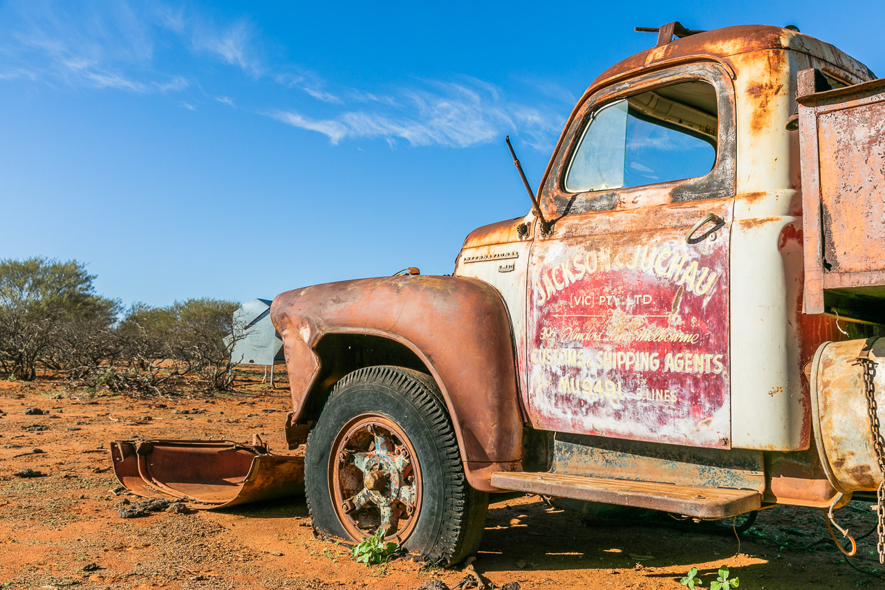 Old rusty vehicles and faded signage at Carey Downs Station