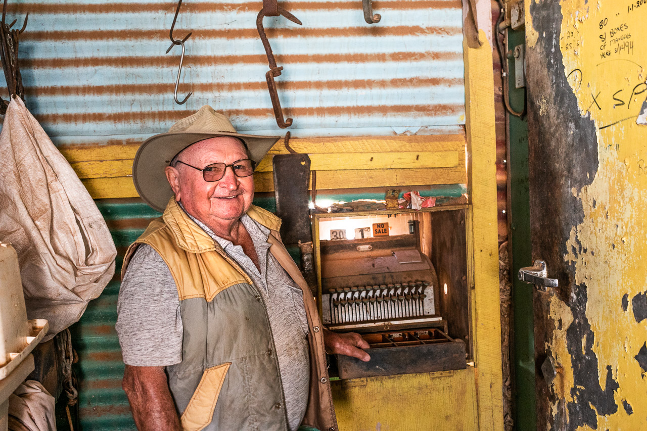 Man in his old shop with vintage till