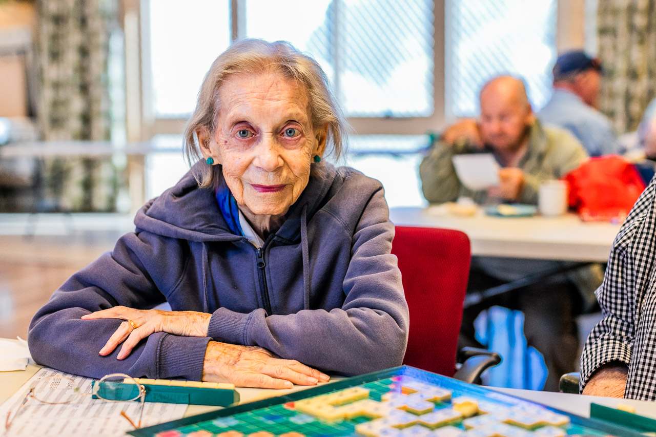 Elderly lady smiling and playing scrabble