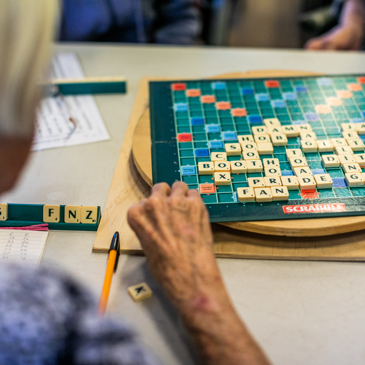 Old lady's hand a scrabble board